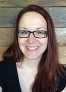 a brown haired woman with glasses smiling