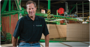 Timber Products employee sitting in front of stacks of lumber.