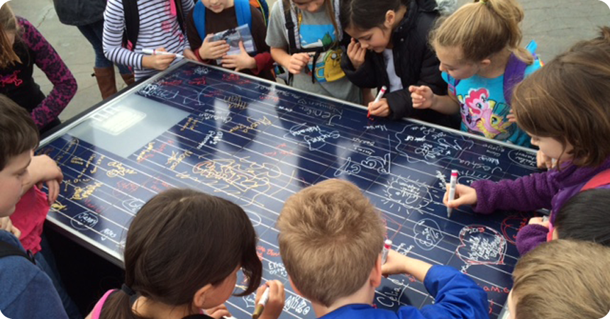 Students at Arleta School sign a demonstration solar panel.