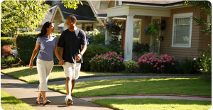 a man and woman walking hand in hand on a residential sidewalk