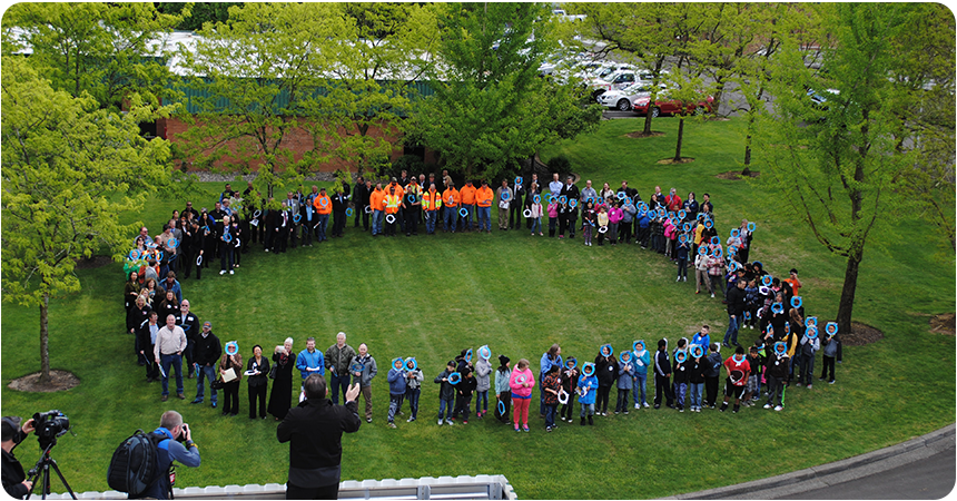 a group of adults and children forming a giant zero