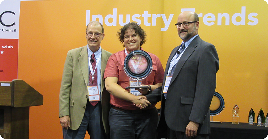 an Energy Trust employee, Jeni Hall, receiving a trophy