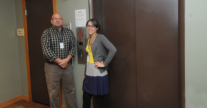 a man and woman standing in front of an elevator door