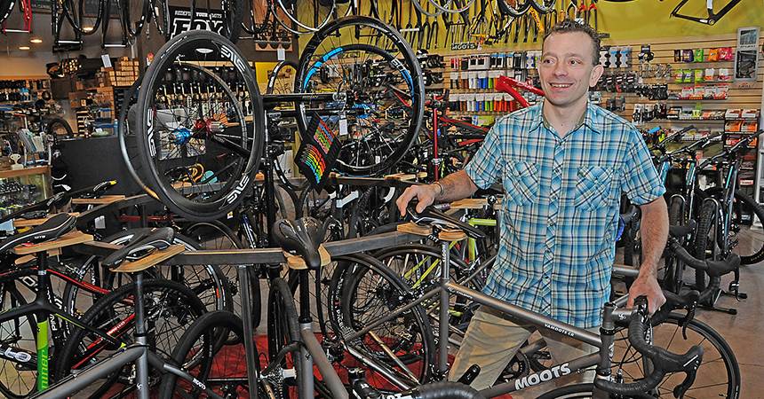 a man in a bikeshop, surrounded by colorful bicycles