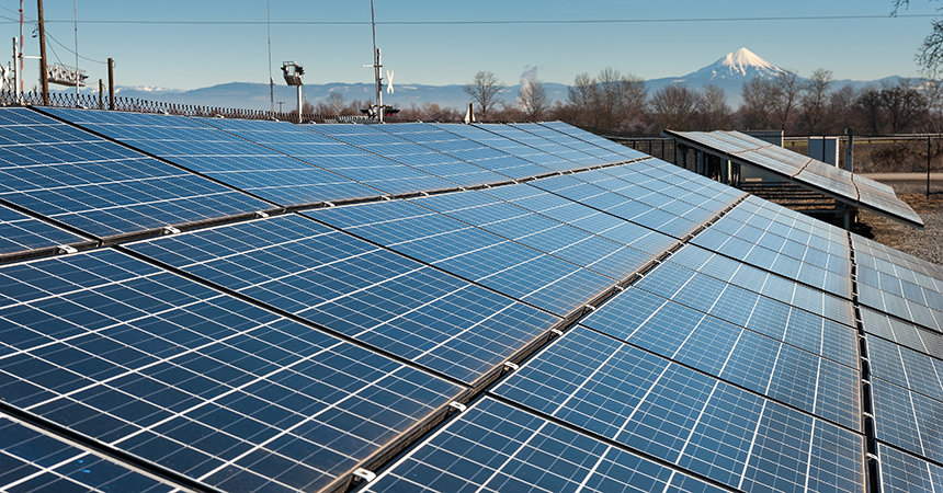 a solar array with a mountain in the distance