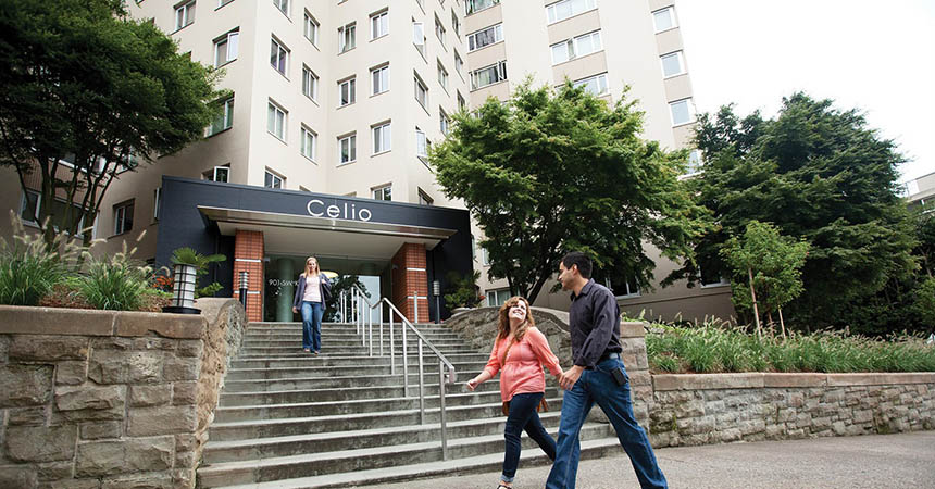 man and woman walking in front of a larg apartment building