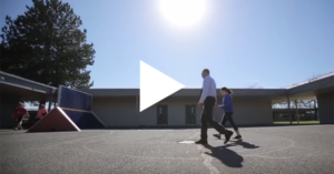 Principal and student, walking in front of school building