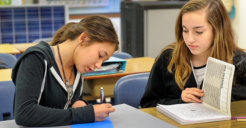 two young woman studying in a classroom