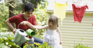 Mother and daughter watering garden plants