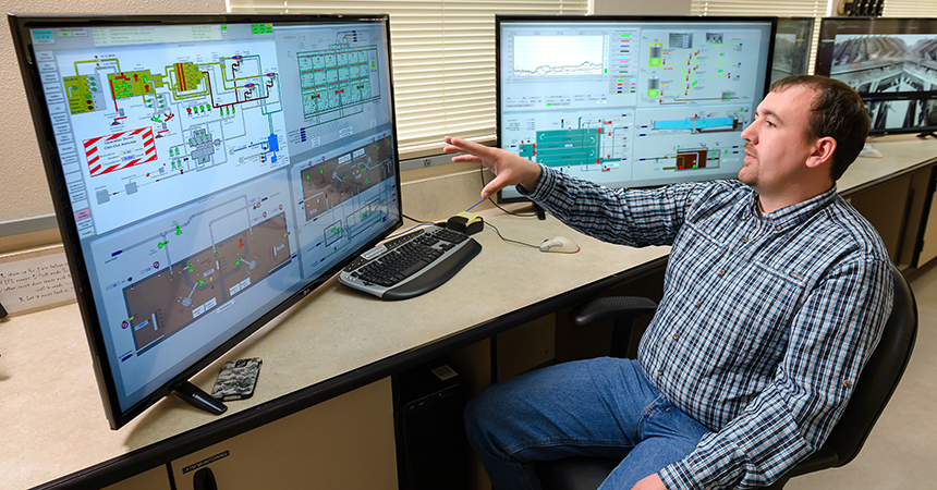 plant employee looking at schematics on a computer
