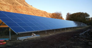 large solar array in front of sunlit cliff