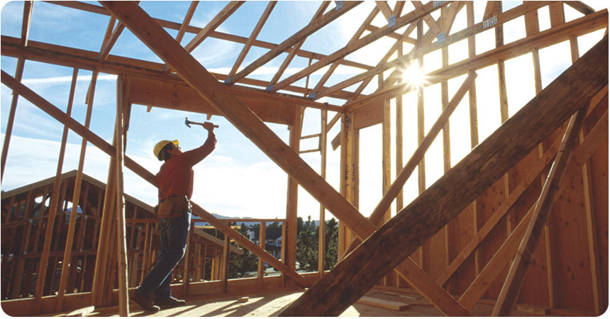 a man constructing a wooden framed house