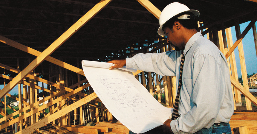 a contractor looks over building blueprints on a job site