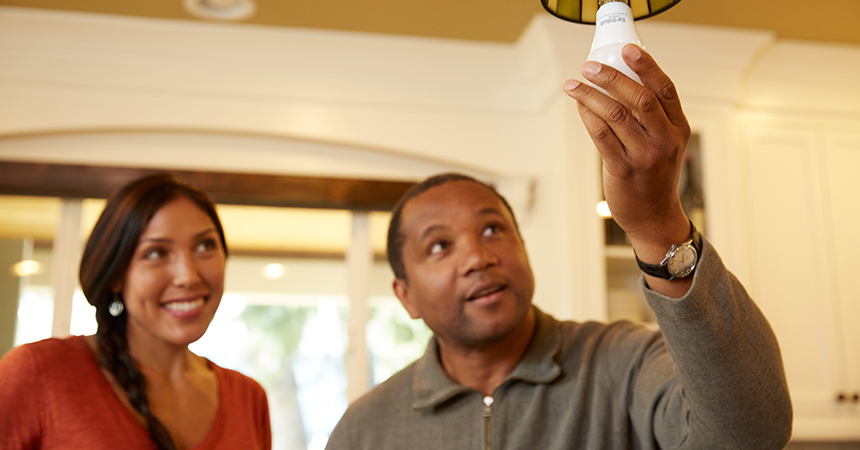 Homeowners screwing in a light bulb