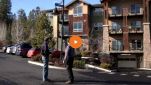 two men talking outside a multifamily property