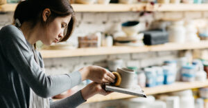 Young female making ceramics working with clay.