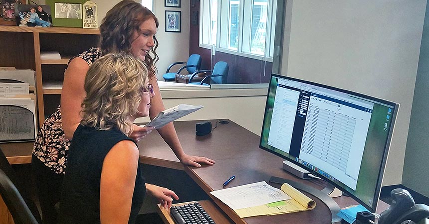 Commercial SEM intern Cacey Thomas and facilities support supervisor Anne Birky working on the energy management database for Bend-La Pine School District.