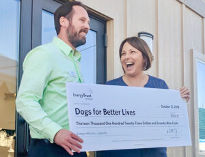 two people holding a big incentive check for Dogs for Better Lives