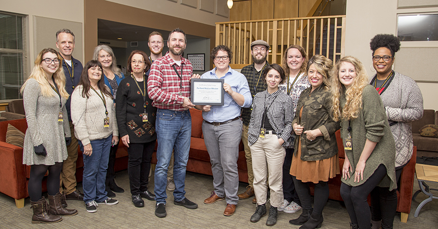 Employees of Energy Trust of Oregon and Shepherd's Door pose with a certificate honoring solar energy upgrades made to the Shepherd's Door facility in Northeast Portland, November 28, 2018.