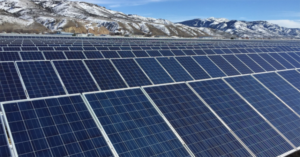 a solar array with snowy mountains in the background