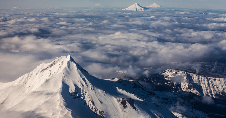 snow covered mountain peak above the clouds