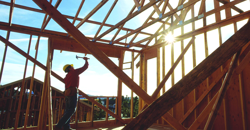 a man putting together a house frame on a sunny day