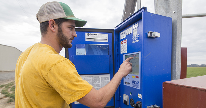 Seth Buck operates controls on a linear irrigation system at Blue Sky Farm in St. Paul, Oregon, 1 October 2018.