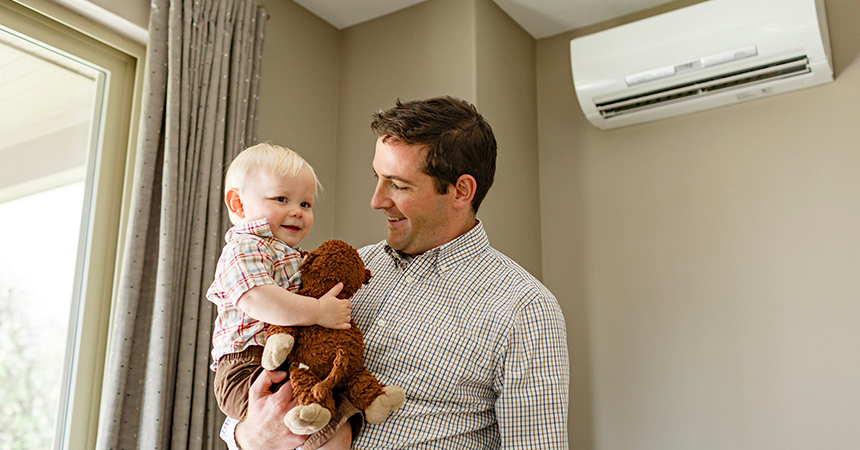 a man and his son in front of a ductless heat pump