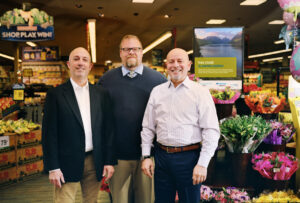 Energy Trust and Alberstons Companies representatives standing in front of flowers and produce at Woodstock Safeway in Portland.