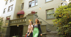 two women walking out of their appartment building