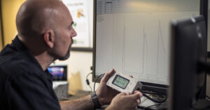 a man looking at an energy reading and a white board