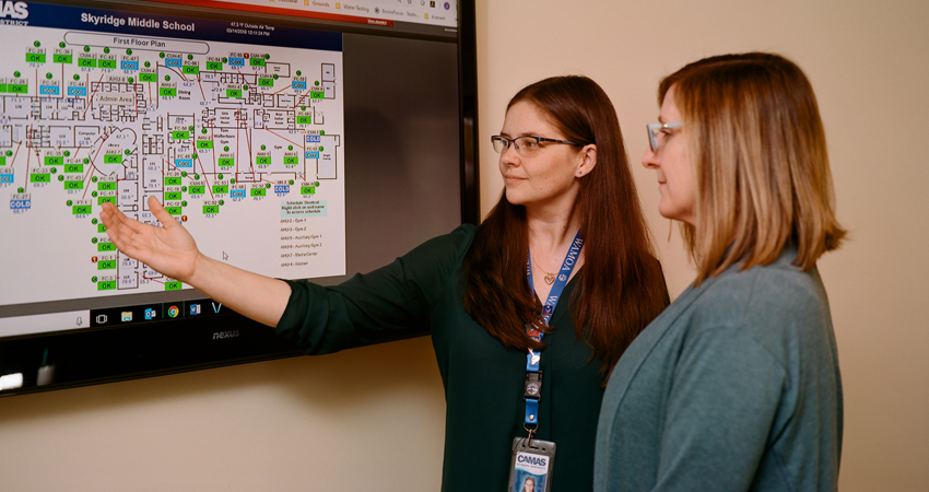 Camas School District operations administrator, Jessica Beehner, reviews the status of Skyridge Middle School’s CO2 sensors via direct digital controls with colleague, Bridget Flanagan at the Zellerbach Administration Center.
