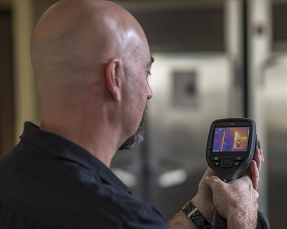 a man using a heat vision tool to look for inefficiency