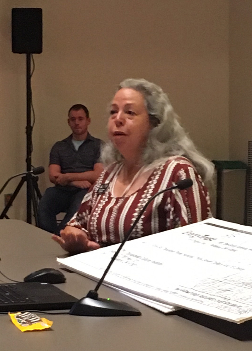 Bobbie Connor shows a stack of ceremonial incentive checks at the Energy Trust board meeting held in Pendleton