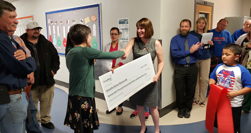 Umatilla School District’s superintendent, Heidi Sipe, accepts a check from Energy Trust. 