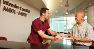 A man checking in a patient at the Salem Hospital Intensive Care Unit.