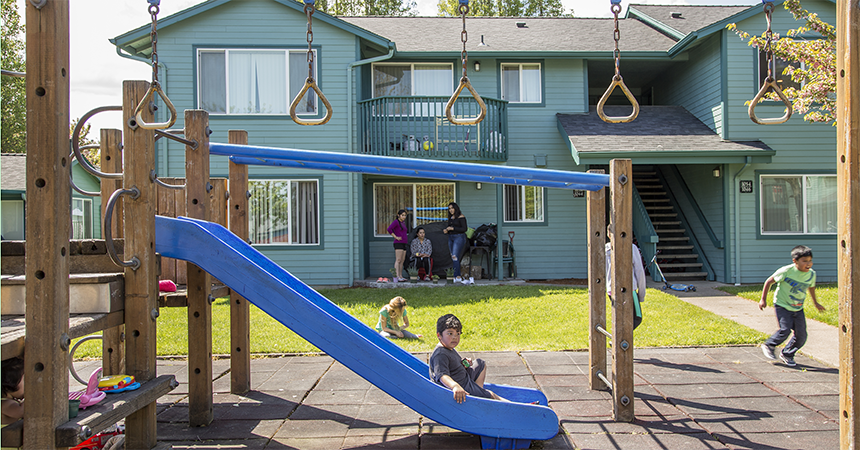 a multifamily building with children playing outside