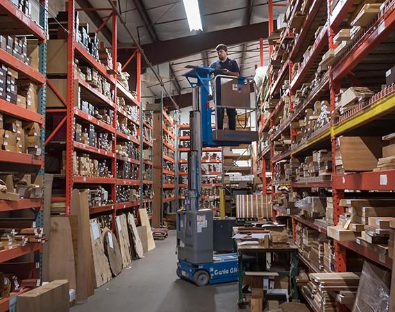 a man on a forklift in a warehouse of lumber