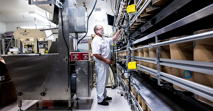 a man in a white jumpsuit observing a factory line