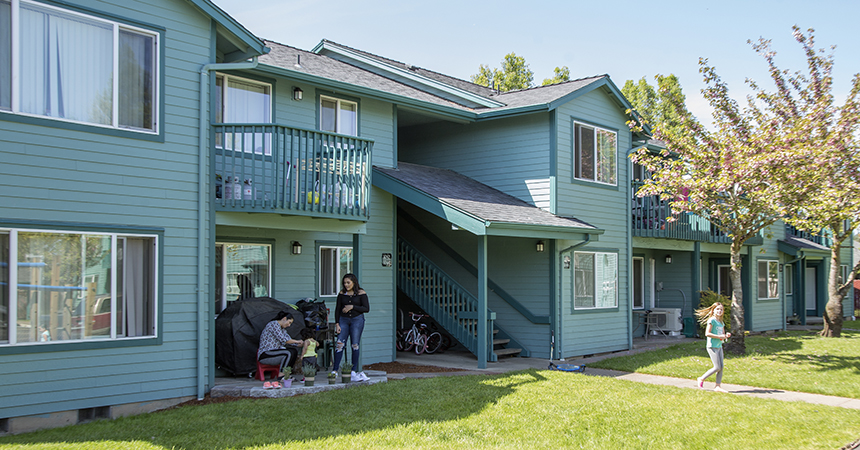 an apartment building with a family on the patio