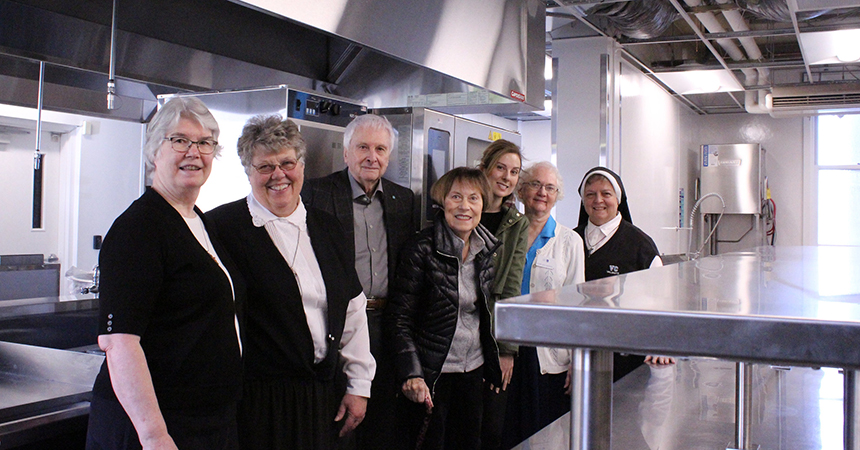 a group of people standing in a kitchen