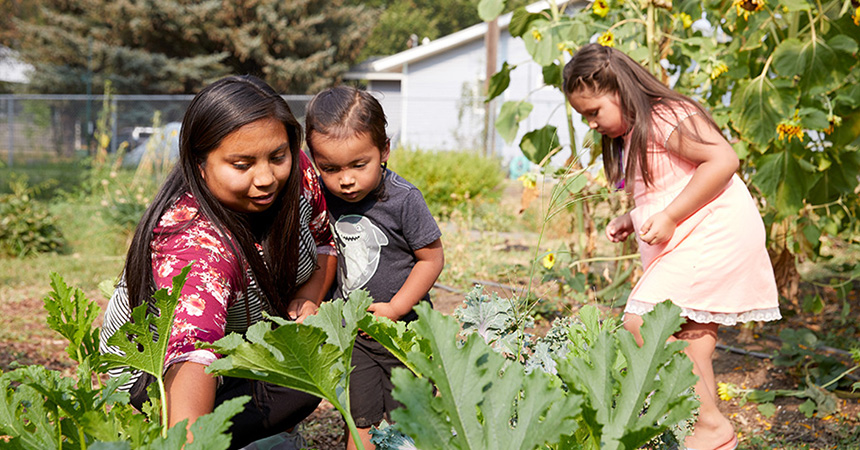 a woman holding a child looking at a garden