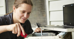 a woman with a screwdriver fixing something