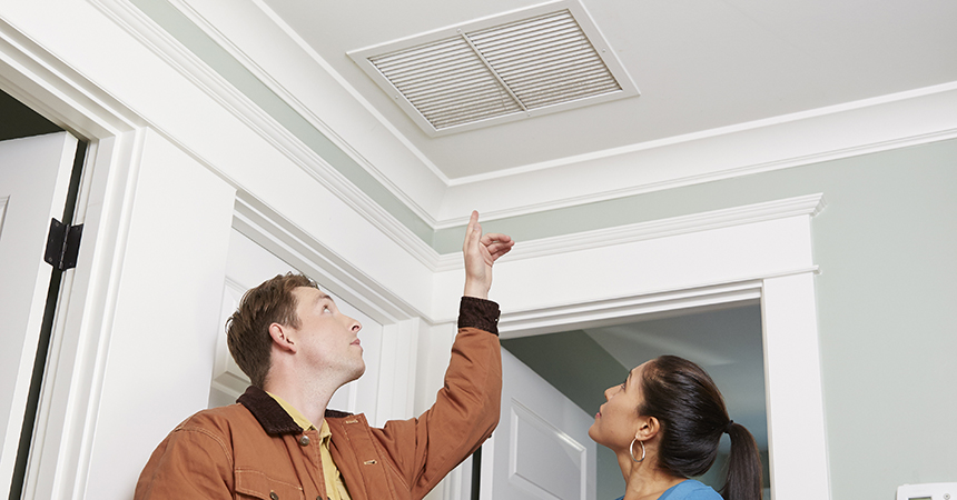 contractor showing homeowner a vent in ceiling