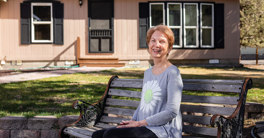 woman sitting in front of her house