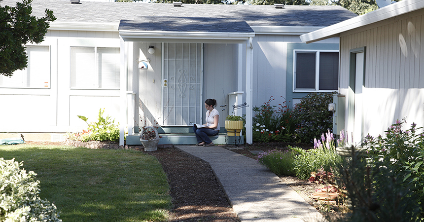 a woman sitting on a porch of a house