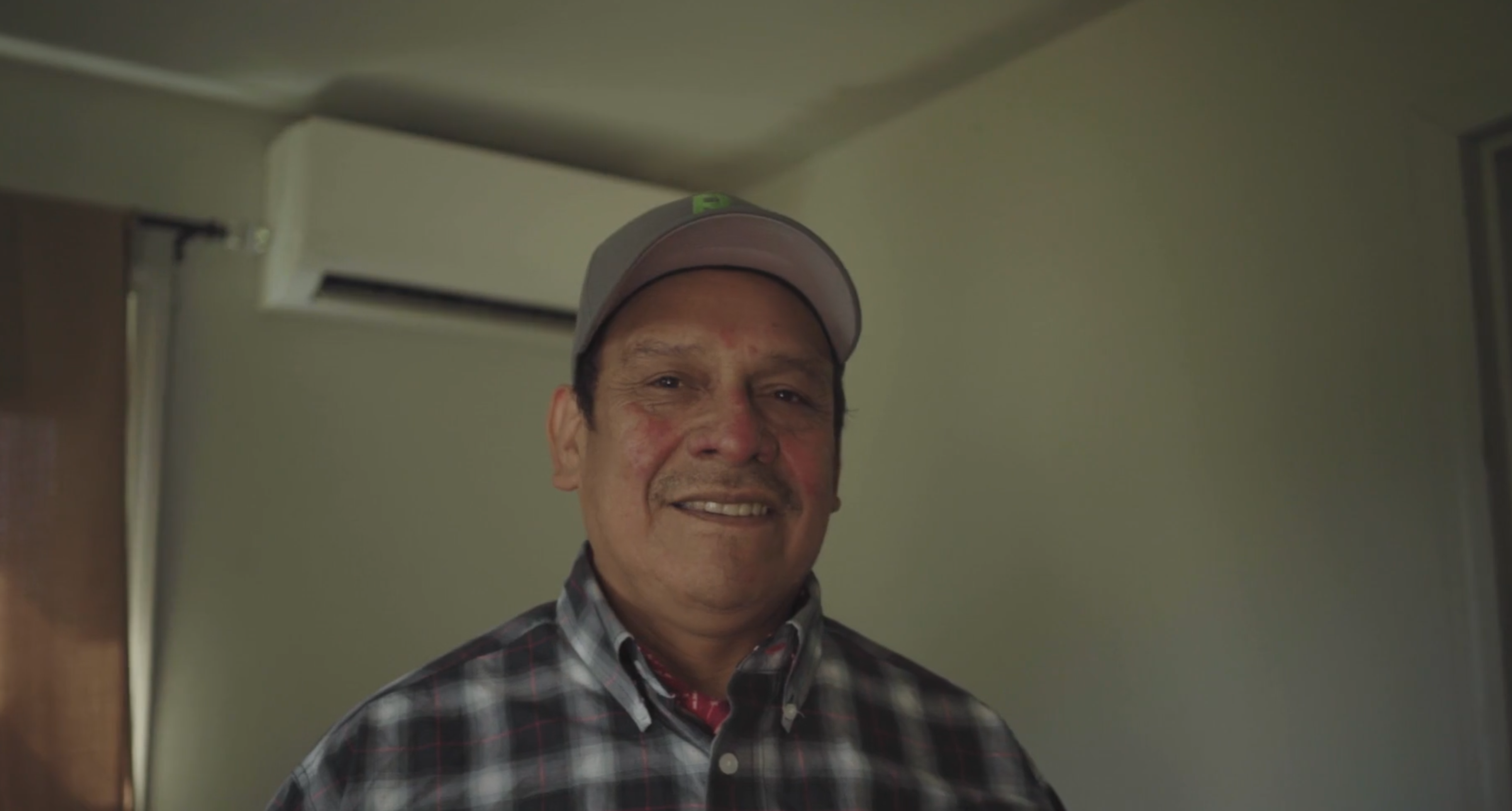 a man standing in front of a ductless heat pump