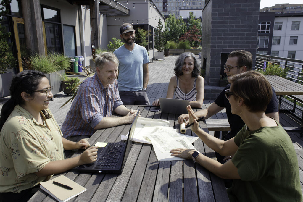 People gathered outside at a wooden table