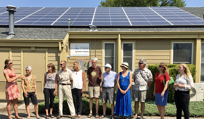 Group in front of house with solar panels