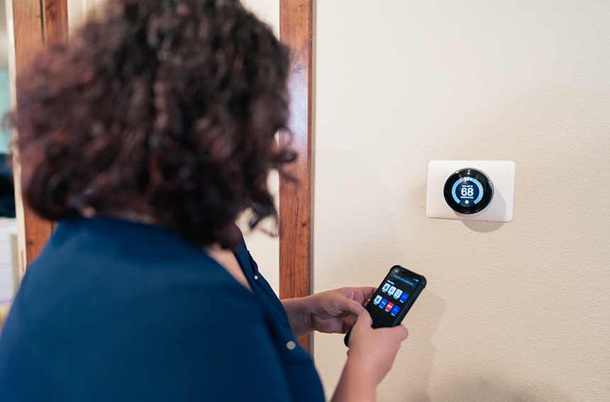 woman adjusting thermostat